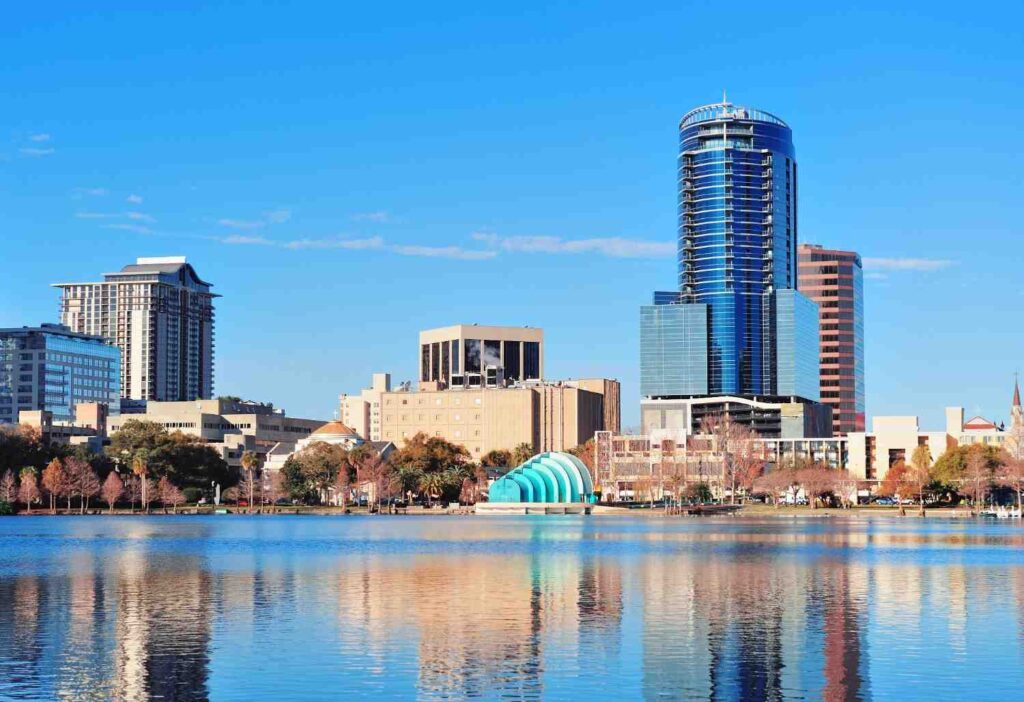Orlando skyline reflected in lake under blue sky