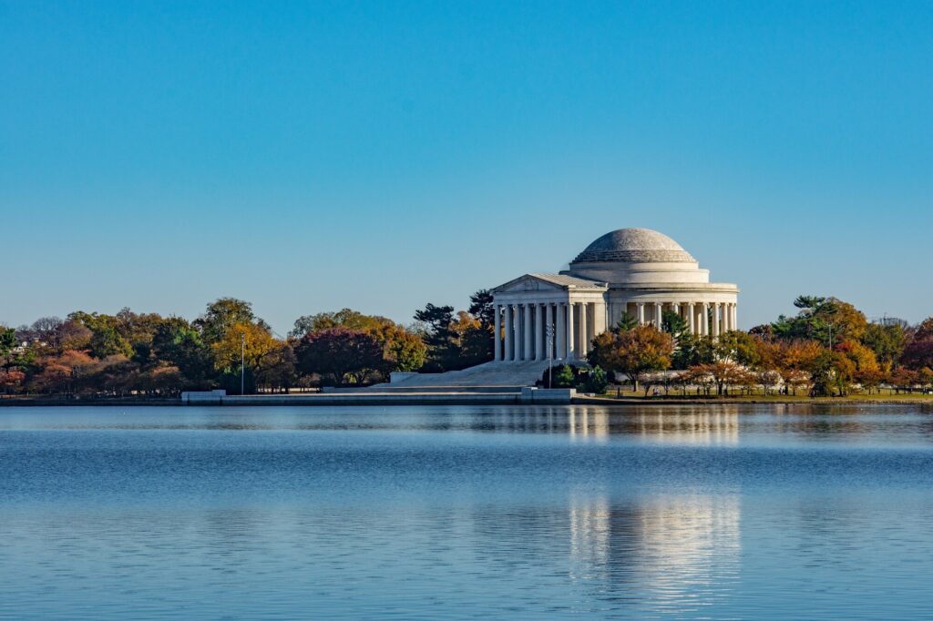 Jefferson Memorial across calm water with autumn trees